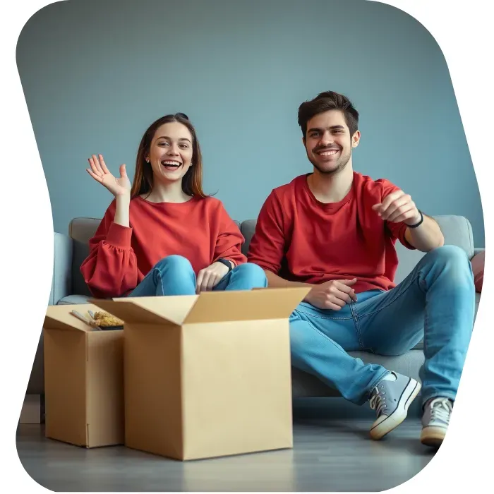 Two guys sitting on the floor of their apartment with Muval moving boxes